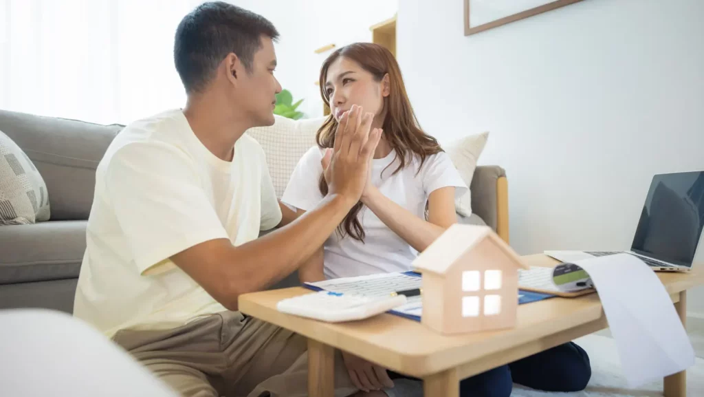 Asian couple in home or house. To compare prices, interest, credit. Include laptop, calculator and document on table. Concept for marriage, loan, finance, insurance, mortgage, real estate and property