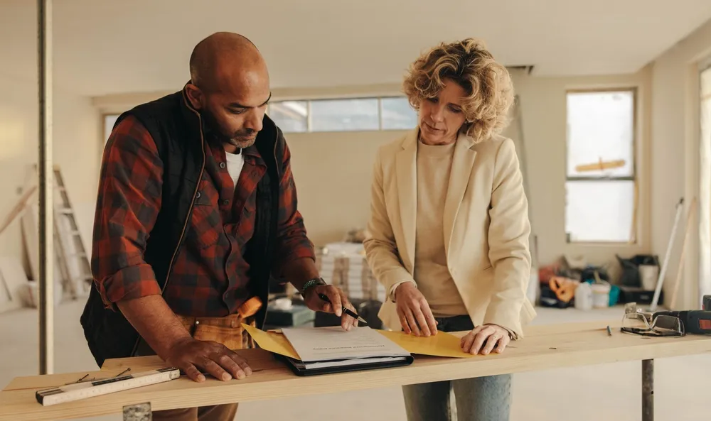 Homeowner discussing plans with a contractor for the best ROI home improvements in Houston.