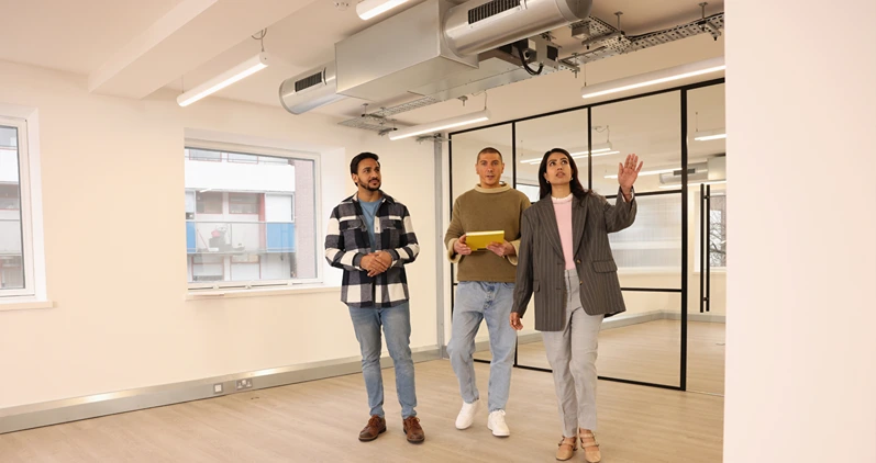 Coworkers holding files and talking in modern empty office